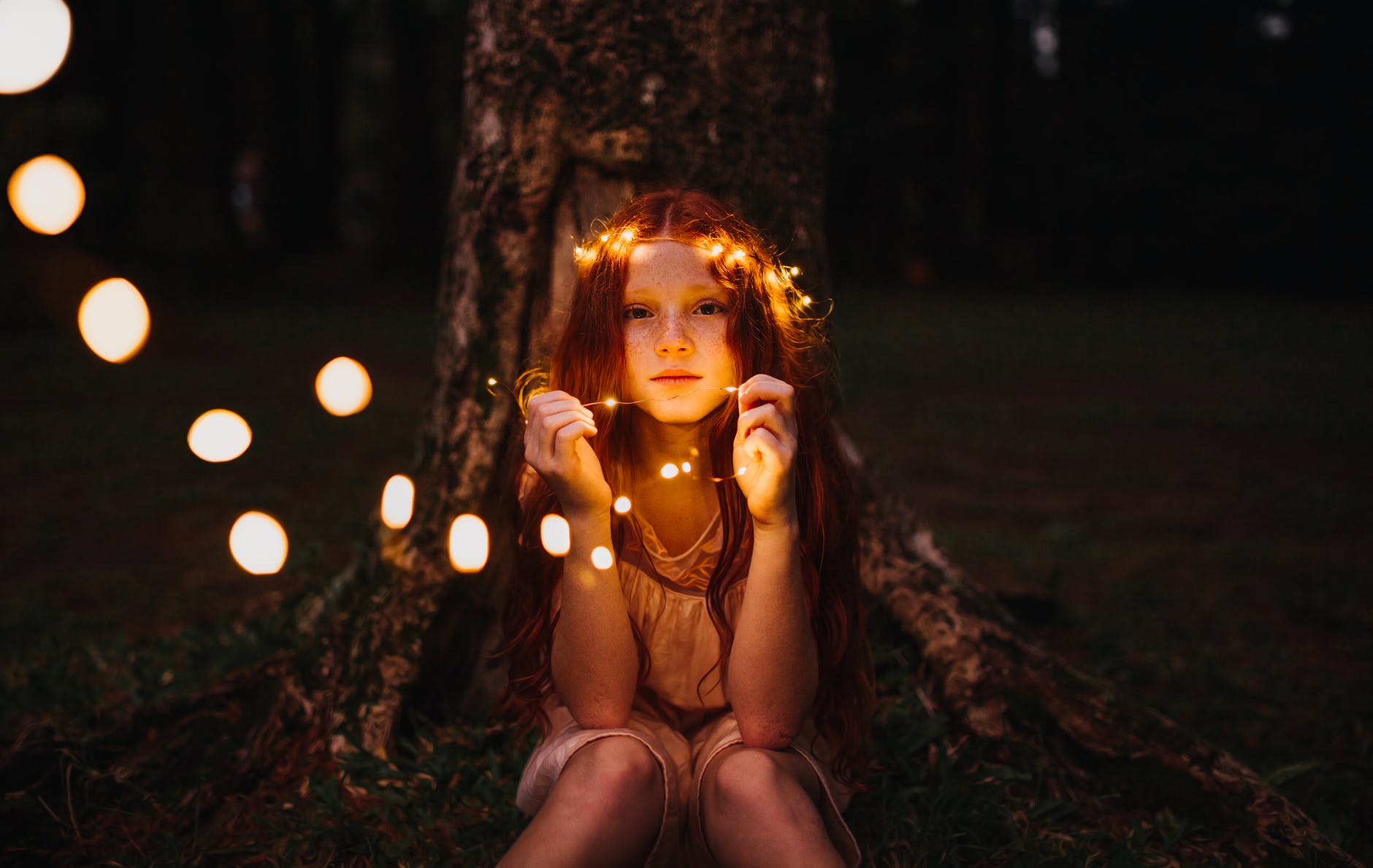 girl holding string lights