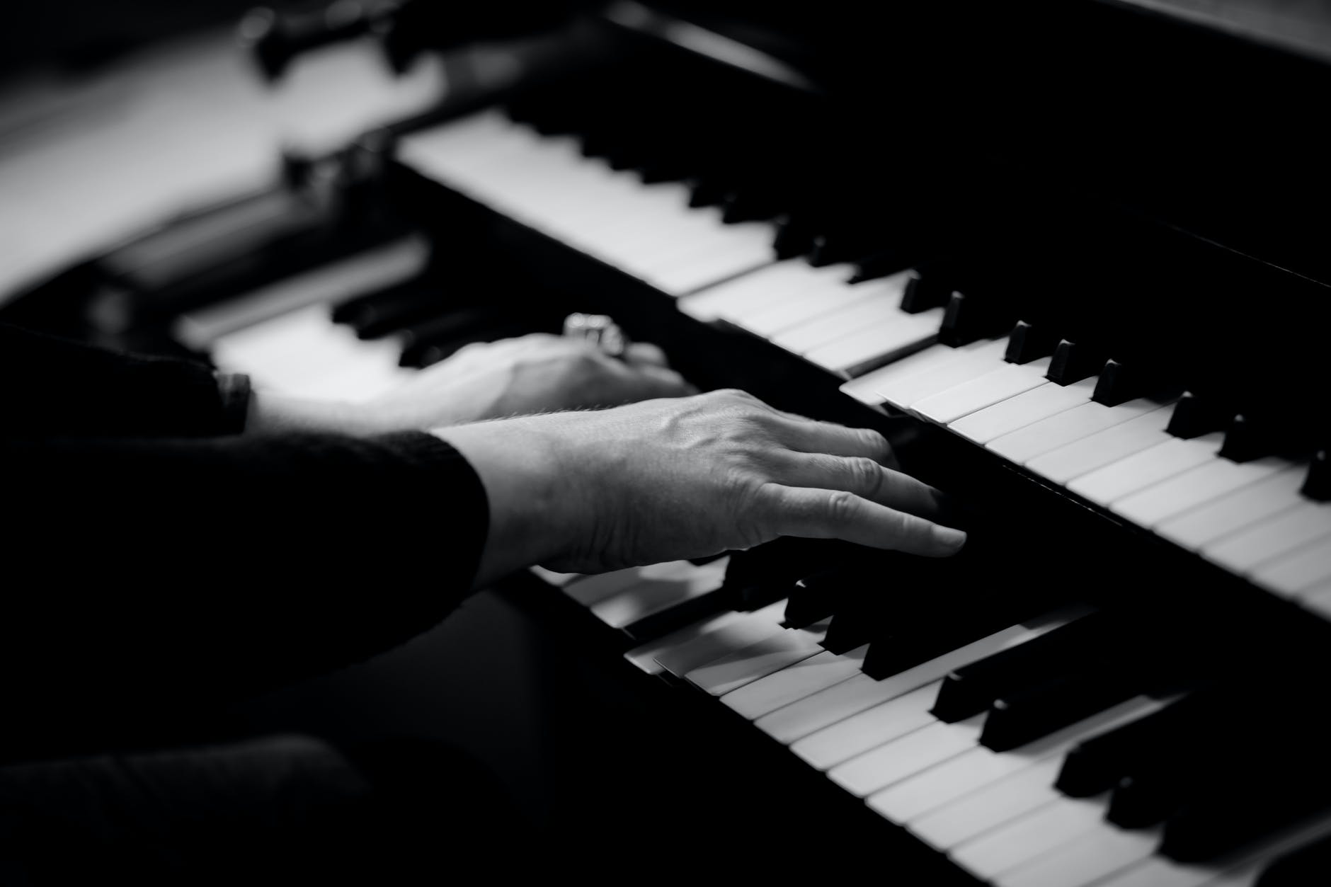 person playing musical organ grayscale photo